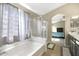 Bathroom featuring a soaking tub, glass shower, and double sinks at 17820 W Charter Oak Rd, Surprise, AZ 85388