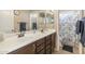 Bathroom featuring double sinks, large mirror, and shower at 17820 W Charter Oak Rd, Surprise, AZ 85388