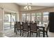 Bright dining room with natural light, stylish chandelier, and sliding door to backyard at 17820 W Charter Oak Rd, Surprise, AZ 85388