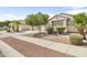 Inviting single-story home showcases desert landscaping, a spacious driveway, and a two-car garage at 17820 W Charter Oak Rd, Surprise, AZ 85388