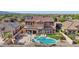 Ariel view of backyard with pool, BBQ, manicured lawn, and covered patio of a beautiful home at 18121 W Las Cruces Dr, Goodyear, AZ 85338