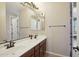 Bathroom with double sink vanity, framed mirrors, and neutral walls. Doors lead to other rooms at 18121 W Las Cruces Dr, Goodyear, AZ 85338