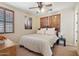 Cozy bedroom with decorative shutters, ceiling fan, and a large black and white print on the wall at 18121 W Las Cruces Dr, Goodyear, AZ 85338