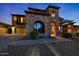Stunning stone-clad two-story home with a unique arched window, a spacious driveway, and well-manicured landscaping at 18121 W Las Cruces Dr, Goodyear, AZ 85338