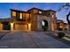 Charming home with a stone facade, arched window, two-car garage, and well-manicured landscaping at 18121 W Las Cruces Dr, Goodyear, AZ 85338