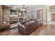Cozy living room showcasing a stone fireplace, plantation shutters, and a comfortable sectional sofa at 18121 W Las Cruces Dr, Goodyear, AZ 85338