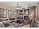 Comfortable living room with stone fireplace, plantation shutters, and ample seating at 18121 W Las Cruces Dr, Goodyear, AZ 85338