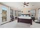Spacious main bedroom with a ceiling fan, balcony, and plantation shutters for a light-filled space at 18121 W Las Cruces Dr, Goodyear, AZ 85338