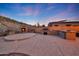 Backyard featuring an outdoor kitchen with built-in grill and a cozy fire pit area for entertaining at 18121 W Las Cruces Dr, Goodyear, AZ 85338