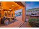 Covered patio with a cozy seating area, outdoor kitchen, pizza oven, and a view of the refreshing pool at 18121 W Las Cruces Dr, Goodyear, AZ 85338