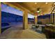Covered patio with a ceiling fan, string lights, outdoor kitchen, and desert views, perfect for outdoor living at 18121 W Las Cruces Dr, Goodyear, AZ 85338