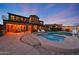 Backyard oasis with a sparkling pool, spa, covered patio, and outdoor kitchen for ultimate relaxation at 18121 W Las Cruces Dr, Goodyear, AZ 85338