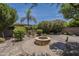 Secluded backyard with lush landscaping, fire pit, and desert flora at 1838 W Enfield Way, Chandler, AZ 85286