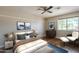 Cozy bedroom features a ceiling fan, wood floors, and a window providing natural light at 1838 W Enfield Way, Chandler, AZ 85286