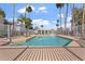 Community pool with lounge chairs surrounded by tall palm trees and a white fence at 18644 N 5Th Ave, Phoenix, AZ 85027