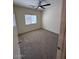 Bedroom with neutral carpet, large window, and ceiling fan for comfort at 20985 N 81St Dr, Peoria, AZ 85382