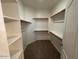An organized walk-in closet with wood shelving and carpeted floors at 20985 N 81St Dr, Peoria, AZ 85382