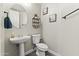 Stylish half-bathroom with modern fixtures, a pedestal sink, and tasteful decor, offering convenience at 2144 E Honeysuckle Pl, Chandler, AZ 85286