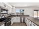 Bright kitchen with stainless appliances, gray counters and white cabinets, under a window at 2220 S Cottonwood Dr, Tempe, AZ 85282