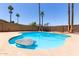 Outdoor pool with in-pool seating and surrounded by rock landscaping and mature palm trees at 2220 S Cottonwood Dr, Tempe, AZ 85282