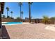 Backyard featuring a pool, rock landscaping, a block wall, and mature palm trees at 2220 S Cottonwood Dr, Tempe, AZ 85282