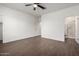 Spacious bedroom with wood-look tile flooring, a ceiling fan, and ensuite bathroom at 22417 W Loma Linda Blvd, Buckeye, AZ 85326