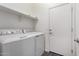 Modern laundry area equipped with a full-size washer and dryer and white shelving above at 22417 W Loma Linda Blvd, Buckeye, AZ 85326