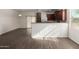 Open living space with wood-look tile flooring, flowing into a modern kitchen with stainless appliances and dark cabinets at 22417 W Loma Linda Blvd, Buckeye, AZ 85326