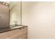 Modern bathroom vanity features light wood cabinets, dark countertops and a sleek mirror with modern fixtures at 2300 E Campbell Ave # 114, Phoenix, AZ 85016