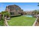 Exterior view of a home with a pool, covered patio, and green grass at 23081 S 223Rd Way, Queen Creek, AZ 85142