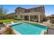 Exterior view of a home with a pool, covered patio, and green grass at 23081 S 223Rd Way, Queen Creek, AZ 85142