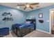 Blue bedroom features a black bedframe, a ceiling fan, and neutral carpet at 23081 S 223Rd Way, Queen Creek, AZ 85142