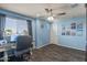 Comfortable bedroom features hardwood floors, a ceiling fan, a desk, and blue accent walls at 23081 S 223Rd Way, Queen Creek, AZ 85142