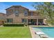 Exterior view of a home with a pool, covered patio, and green grass at 23081 S 223Rd Way, Queen Creek, AZ 85142