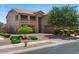 Home exterior featuring a three-car garage, balconies, desert landscaping, and a brick driveway at 23081 S 223Rd Way, Queen Creek, AZ 85142