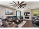 Open living room with large sectional, ceiling fan, and entertainment center at 23081 S 223Rd Way, Queen Creek, AZ 85142
