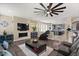 Open concept living room featuring a fireplace, tv and modern fan at 23081 S 223Rd Way, Queen Creek, AZ 85142