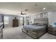 Spacious main bedroom featuring carpet floors, gray walls, barn-style door to bath, and a stylish ceiling fan at 23081 S 223Rd Way, Queen Creek, AZ 85142
