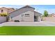 Manicured backyard featuring turf and gravel, with views of the home's exterior at 23645 W Parkway Dr, Buckeye, AZ 85326