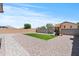 Landscaped backyard featuring a grassy patch, stone pavers, and a playset for outdoor enjoyment at 23645 W Parkway Dr, Buckeye, AZ 85326