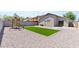 Beautiful backyard with a lush grassy area, desert landscaping, and a charming playset at 23645 W Parkway Dr, Buckeye, AZ 85326