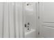 Bathroom with white tiled shower and curtain, next to a white door at 23645 W Parkway Dr, Buckeye, AZ 85326