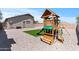 Backyard view showcases a wooden playset, turf, and gravel for endless outdoor fun at 23645 W Parkway Dr, Buckeye, AZ 85326