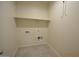 Utility room with tile floor, white paint, and an upper shelf, plus water and dryer hook-ups at 24646 N Barley Rd, Florence, AZ 85132