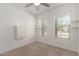 Bright bedroom featuring neutral carpet, two windows, and a ceiling fan at 24746 N 171St Ln, Surprise, AZ 85387