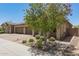 Beautiful home exterior featuring a large, blossoming tree in a landscaped yard at 24746 N 171St Ln, Surprise, AZ 85387