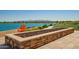 Lakefront view with a beautiful, stone fire pit and colorful Adirondack chairs for relaxing outdoors at 24746 N 171St Ln, Surprise, AZ 85387