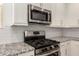 Modern kitchen with stainless steel microwave, range, and granite countertops at 24746 N 171St Ln, Surprise, AZ 85387