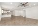 Open-concept living space with tile floors, a ceiling fan, and a kitchen area in the background at 24746 N 171St Ln, Surprise, AZ 85387