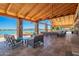 A covered outdoor patio with amazing wooden beams offers relaxing seating and lake views at 24746 N 171St Ln, Surprise, AZ 85387